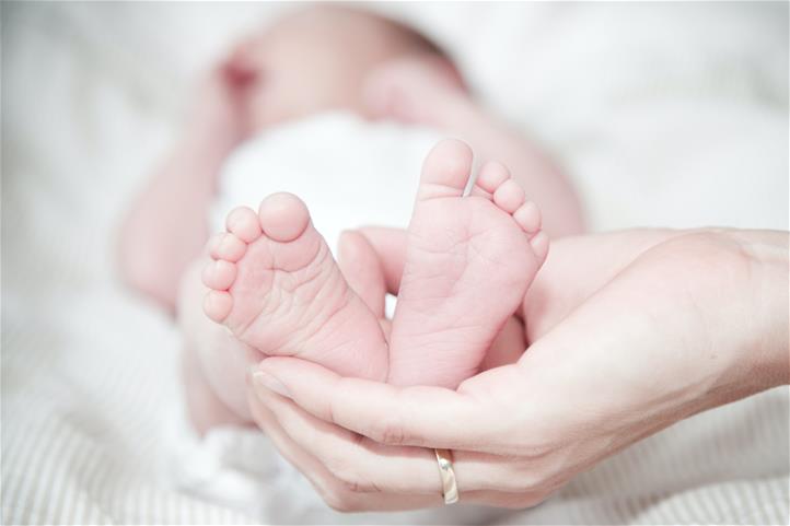 Hand holding an infants feet