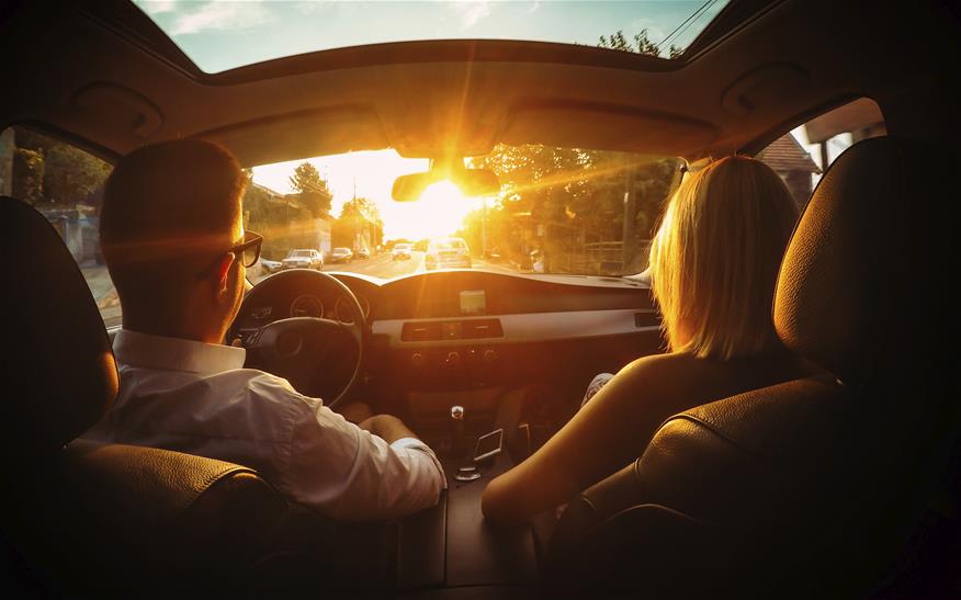 car driving at sunset with couple