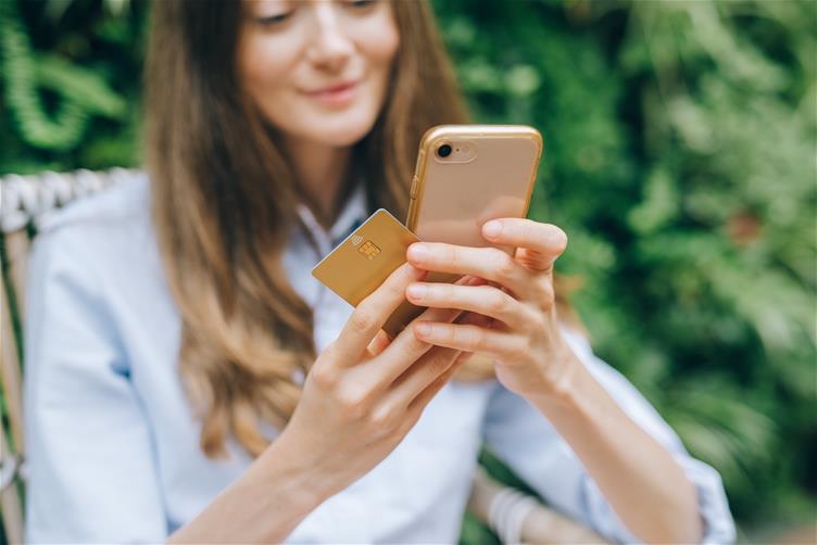 Woman holding cred card and mobile phone