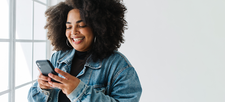 Smiling woman using her mobile phone