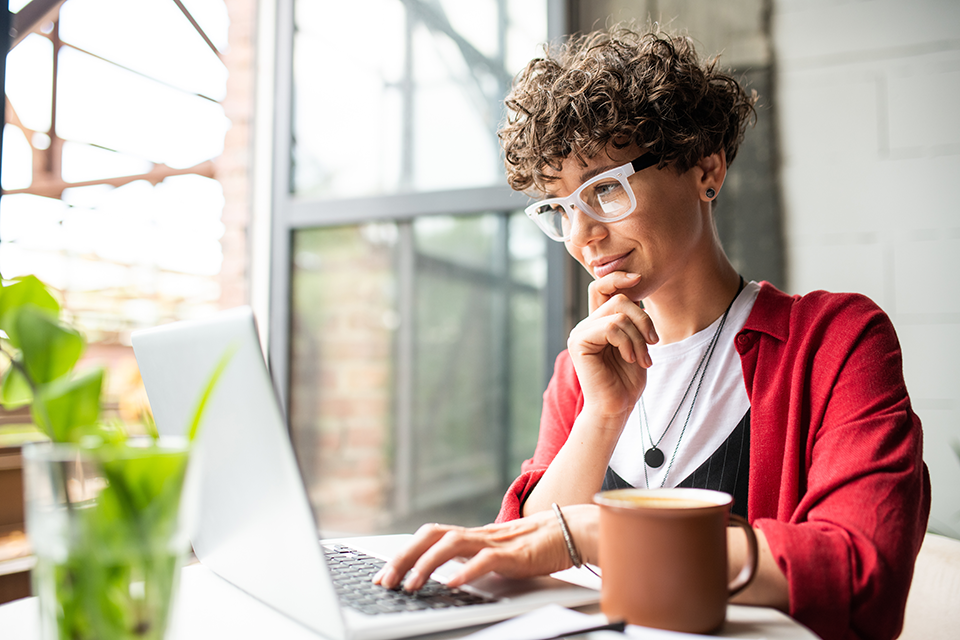 Woman sitting at desk working on laptop.