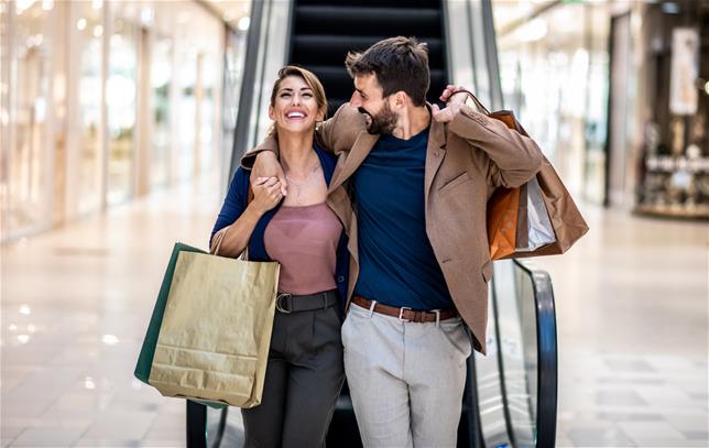 Man with arm around woman's shoulder shopping