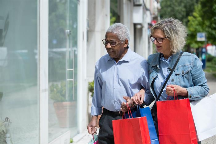 Senior man and woman arm and arm shopping