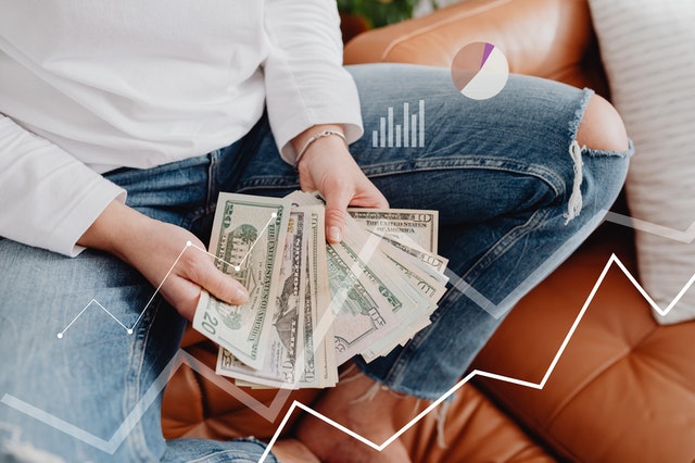 Person sitting on couch holding money