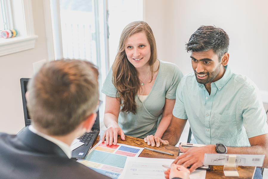 Couple in office filling out paperwork.