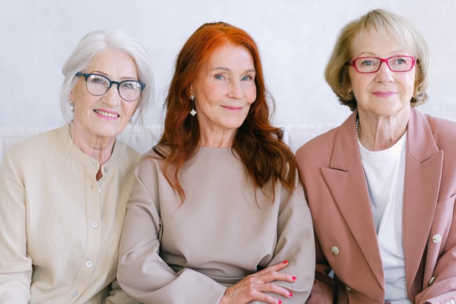 Three senior women sitting together smiling at camera