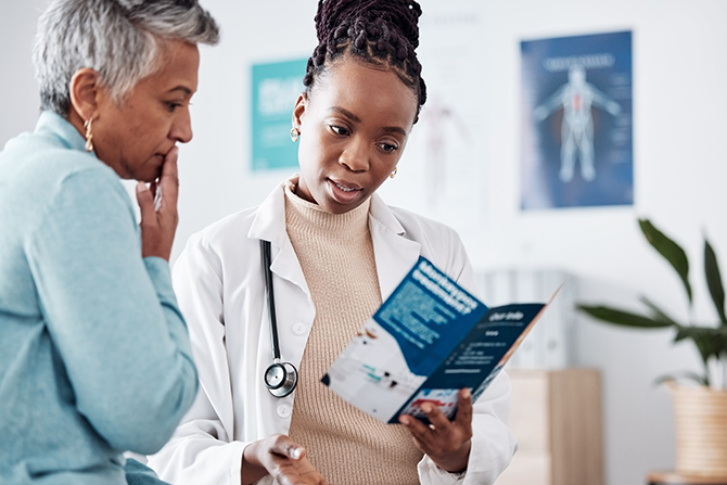 Woman doctor going over health brochure with woman patient