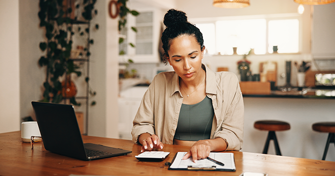 woman working on budget sitting at kitchen table