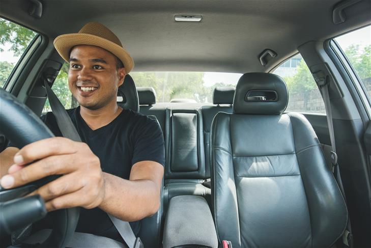 Man smiling while driving in a car.