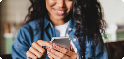 Woman using mobile phone while smiling