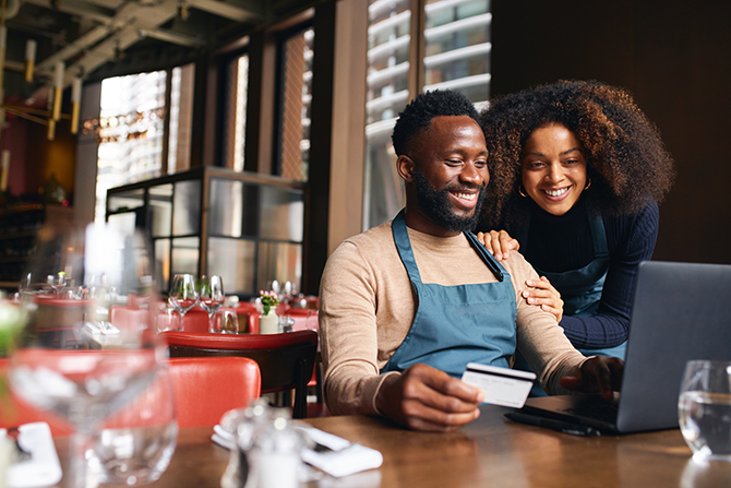 man and woman business partners working on computer