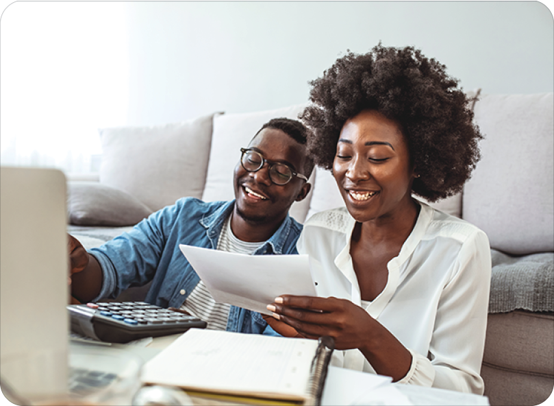 cheerful young couple analyzing finances on laptop