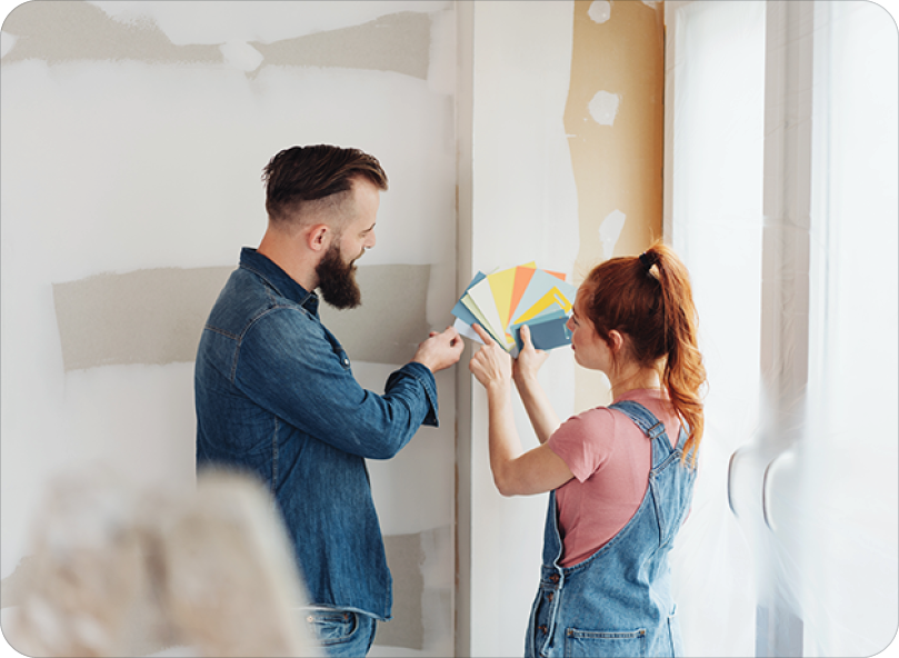 Couple discussing different paint swatches for homes living room