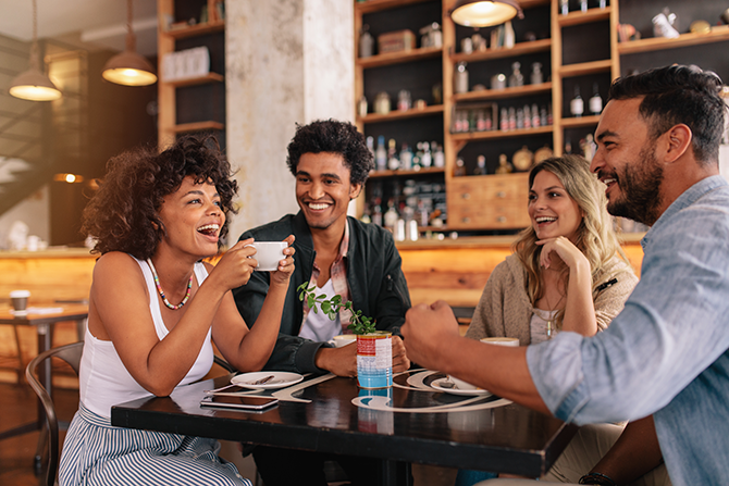 Friends sitting in a cafe laughing over coffee