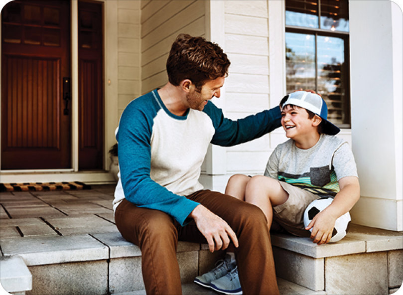 Happy father with son on front porch ready for playing soccer
