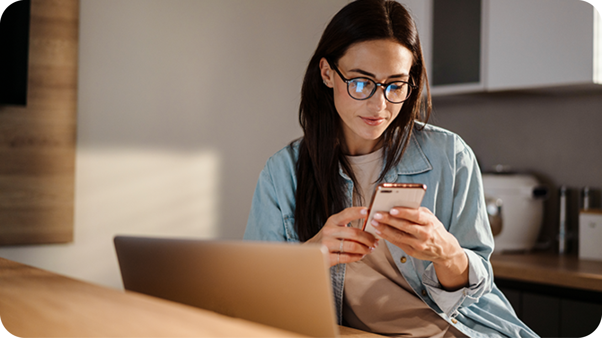 Serious woman looking at mobile phone sitting at desk