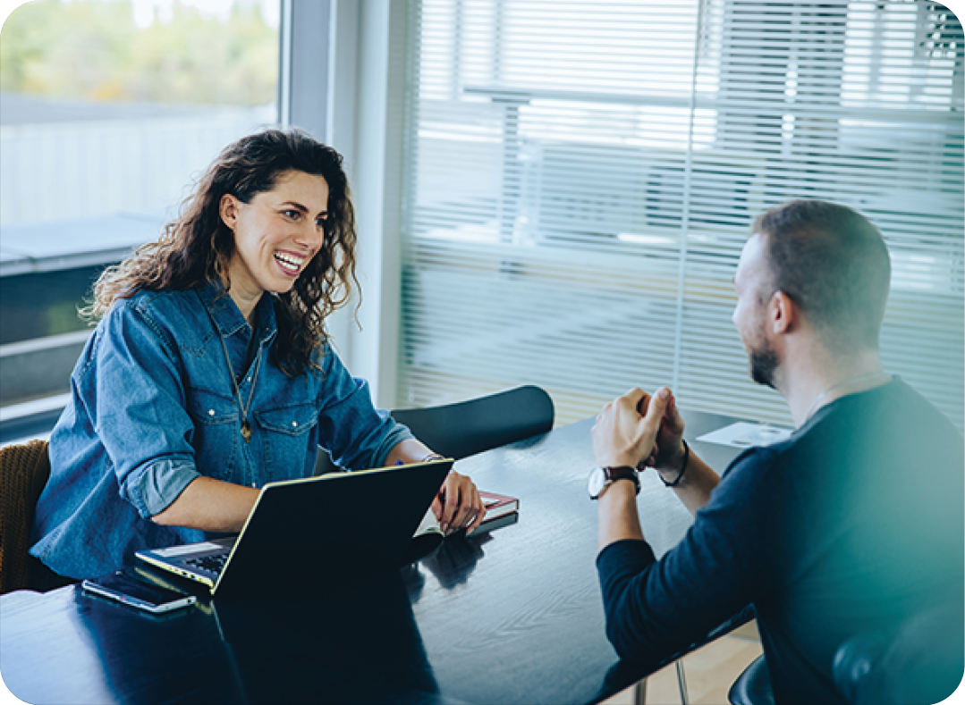 Smiling businesswoman chatting with male coworker