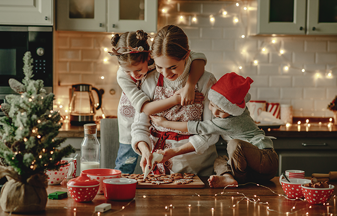 two kids hugging mother baking cookies