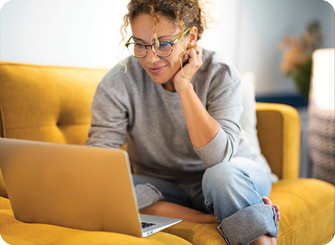 woman lounging on couch using laptop