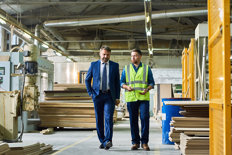 Two men walking and talking in warehouse