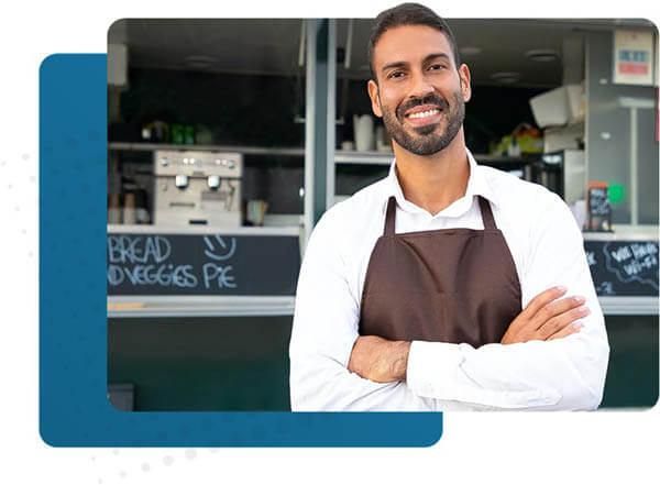 man in apron in front of food truck