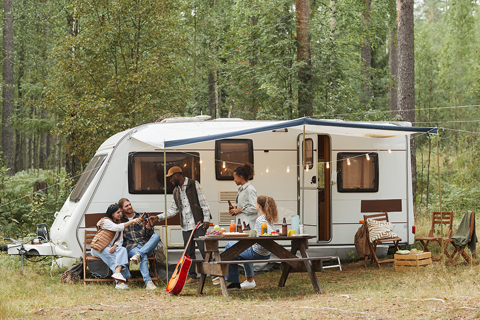 Friends relaxing outside their camper. Friends relaxing outside their camper.