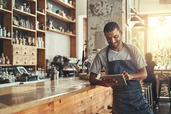 Happy male owner of cafe using digital tablet Happy male owner of cafe using digital tablet