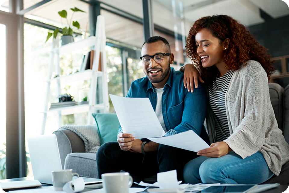 happy couple with budget paperwork and planning savings in home happy couple with budget paperwork and planning savings in home